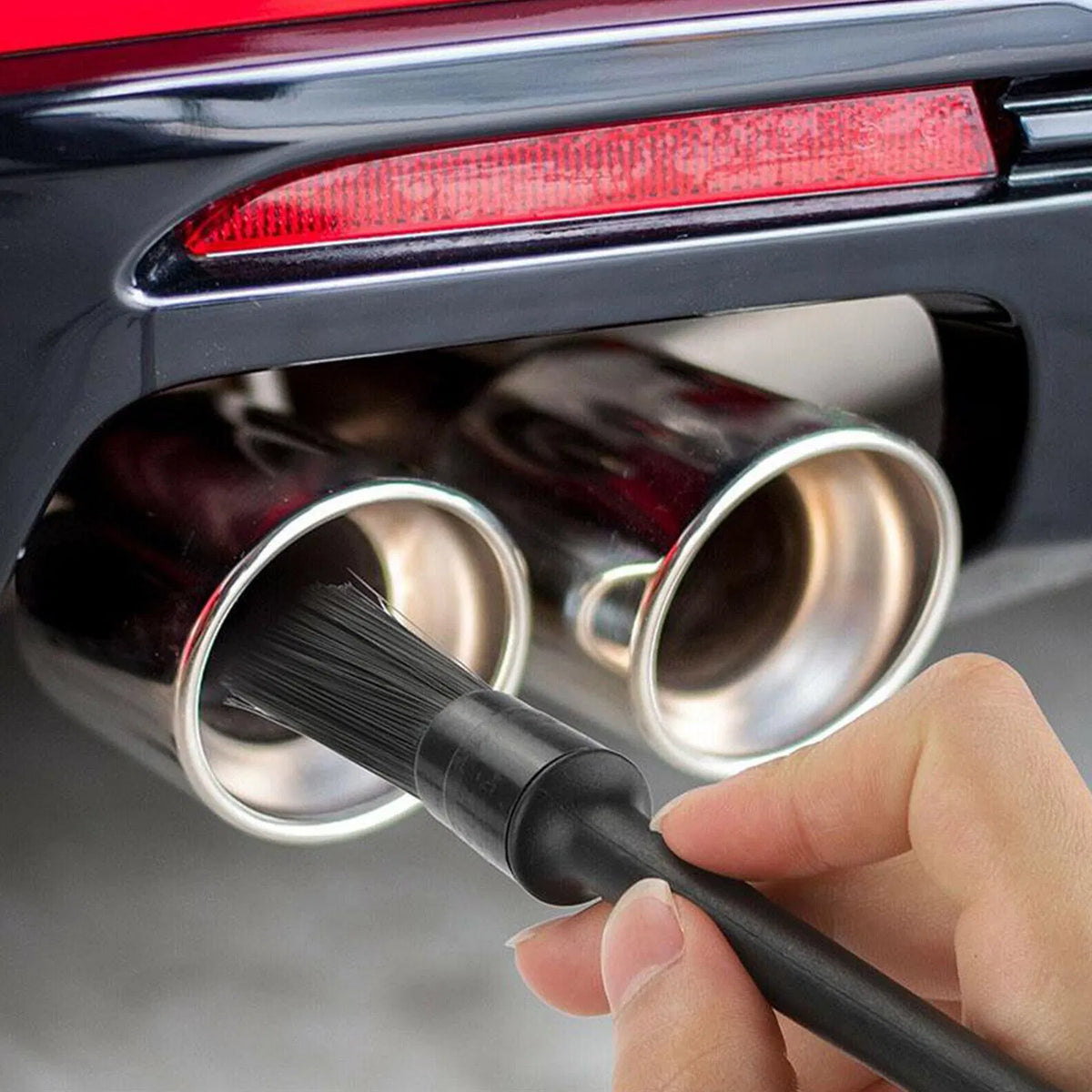 Detailing brush cleaning a chrome exhaust tip